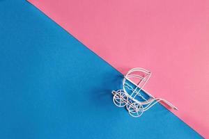 vintage baby stroller on pink and blue background. Boy or girl question photo