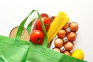 bolsa verde llena de alimentos de productos saludables sobre un fondo blanco. vista superior. Tienda online. tu texto. entrega de comida foto