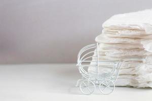 Baby diapers with toy carriage on a white background photo