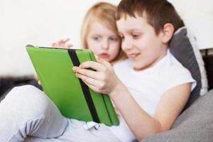 happy children playing with tableton bed . Distance learning online education for kids. Quarantine and self-isolation. photo