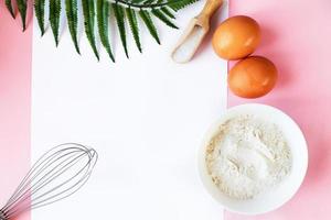 Ingredients for cooking baking - flour, egg, sugar, rolling pin on pink background. Concept of cooking dessert. photo