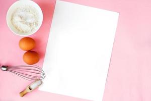 Ingredients for cooking baking - flour, egg, sugar, rolling pin on pink background. Concept of cooking dessert. photo