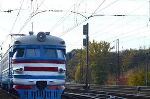 Old soviet electric train with outdated design moving by rail photo