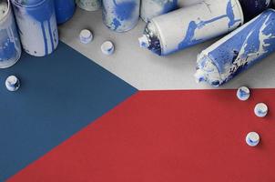 bandera checa y pocas latas de aerosol usadas para pintar graffiti. concepto de cultura de arte callejero foto