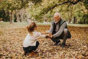 abuelo pasando tiempo con su nieta en el parque el día de otoño foto