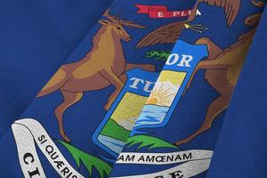 Michigan US state flag with big folds waving close up under the studio light indoors. The official symbols and colors in banner photo