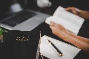 Young woman person hand holding holy bible with study at home. Adult female christian reading book in church. Girl learning religion spirituality with pray to god. concept of student education faith. photo