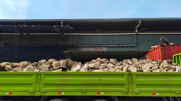 Parte trasera del camión cargado con material de construcción de piedra fundamental. foto