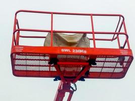 Orange boom lift platform with safety working weight 230 kg. photo