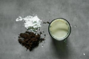 bebida de leche de café con ingredientes crudos sobre fondo de hormigón foto