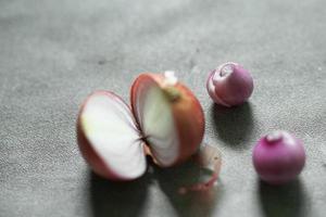 cebolla roja con algunas semillas sobre fondo de hormigón foto