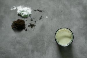 coffee milk drink with raw ingredients over concrete background photo