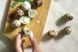 sliced quail eggs on a cutting board on a white background photo