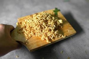 fideos fritos en una tabla de cortar sobre un fondo de hormigón foto