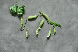 Guisantes frescos listos para cocinar sobre un fondo de hormigón foto