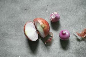 cebolla roja en rodajas con algunas semillas sobre fondo de hormigón foto