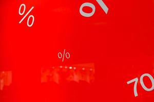 Discount signs on red background shop window in shopping mall. Holiday sale concept photo