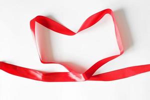 Packing ribbon in the shape of a red heart, top view on a white background photo