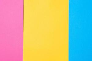 Three colored vertical layers, copy space. Multicolored paper background. Yellow pink and blue geometric backdrop. photo