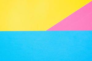 Multicolored paper background. Yellow pink and blue geometric backdrop. Three colors, copy space photo