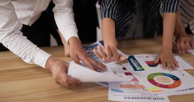 Closeup of hand pointing and explaining the information on the paper with team in the meeting room. Businessman and businesswoman meeting on sales pitch. video