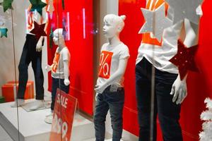 maniquíes de bebé con carteles de descuento rojos en la pantalla. venta navideña de productos para bebés en el centro comercial. rusia smolensk 12.29.2020 foto