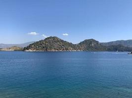 ver rocas. paisaje de verano, mar y montaña. vista marítima. paisajes de la ciudad de turquía marmaris. vista a un mar paradisíaco, agua clara. foto