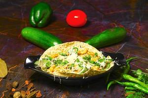 Indian Food known as Masala Papad served as starter food, topping includes onion, tomato, green chilies, fresh coriander etc photo