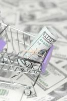 Small shopping trolley with dollars banknotes. Concept of cashback and bargains on sale photo