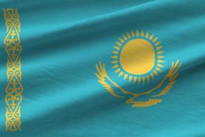 Kazakhstan flag with big folds waving close up under the studio light indoors. The official symbols and colors in banner photo