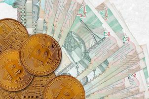 Billetes de 20 baht tailandeses y bitcoins dorados. concepto de inversión en criptomonedas. criptominería o comercio foto