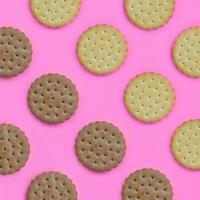 Pattern of a brown biscuits on a pink background. Trendy minimal concept of food and dessert. Abstract flat lay, top view photo