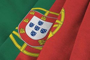 Portugal flag with big folds waving close up under the studio light indoors. The official symbols and colors in banner photo