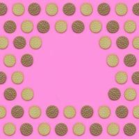 Frame of a brown biscuits on a pink background. Trendy minimal concept of food and dessert. Abstract flat lay, top view photo