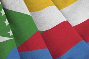 Comoros flag with big folds waving close up under the studio light indoors. The official symbols and colors in banner photo