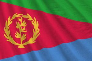 Eritrea flag with big folds waving close up under the studio light indoors. The official symbols and colors in banner photo