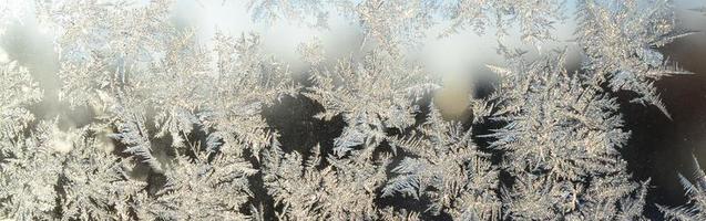 Snowflakes frost rime macro on window glass pane photo