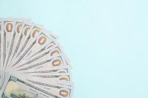 Fan of a US dollar bills of a new design lies on a light blue background photo