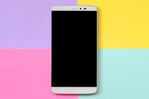 Modern smartphone with black screen on texture background of fashion pastel blue, yellow, violet and pink colors paper in minimal concept photo
