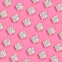 un montón de cajas de regalo rosas se encuentran en el fondo de textura de papel de color rosa pastel de moda en un concepto mínimo. patrón abstracto de moda foto