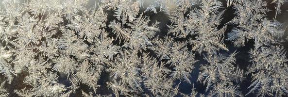 Snowflakes frost rime macro on window glass pane photo