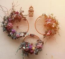 Decoration urban art object from bicycle wheels and flowers on wall photo