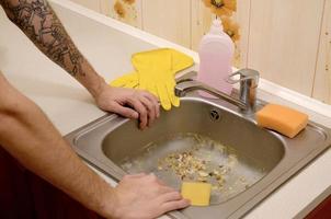 The housekeeper was faced with the problem of washing an overly dirty sink filled with food particles photo