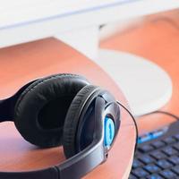 Big black headphones lie on the wooden desktop of the sound designer photo