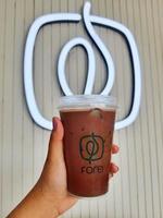 Jakarta, Indonesia in October 2022. A hand is holding an iced moccachino belonging to the Fore brand. photo