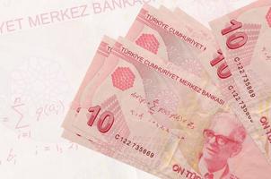 10 Turkish liras bills lies in stack on background of big semi-transparent banknote. Abstract presentation of national currency photo