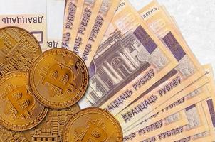 20 Belorussian rubles bills and golden bitcoins. Cryptocurrency investment concept. Crypto mining or trading photo