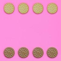 Pattern of a brown biscuits on a pink background. Trendy minimal concept of food and dessert. Abstract flat lay, top view photo