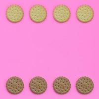 Pattern of a brown biscuits on a pink background. Trendy minimal concept of food and dessert. Abstract flat lay, top view photo