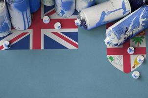 Fiji flag and few used aerosol spray cans for graffiti painting. Street art culture concept photo